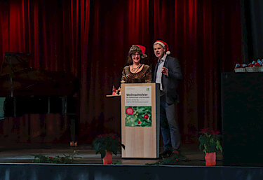 Barbara Ponn und Michael Peukert mit Nikolausmützen auf der Bühne